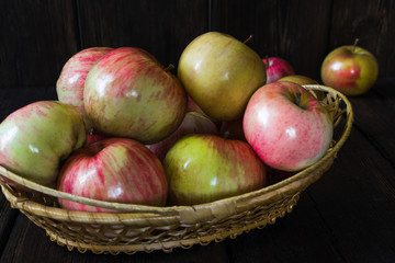 Apples in a basket and honey on a black background.