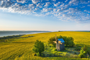 aerial view to old wooden windmill with light clouds in the blue sky with copy space in Ukraine