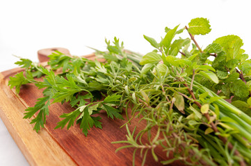 bunch of fresh herbs on a wooden board