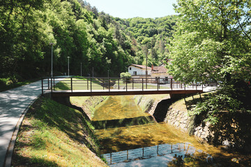 Fototapeta na wymiar Pedestrian bridge leading to the parking spot from walking pathway, crossing Gradna stream in town of Samobor