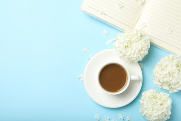 Composition with hydrangea flowers and coffee on blue background