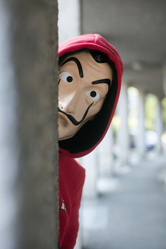 Mulhouse -  France - May 17 2020 : fan of the serie tv "La casa de papel' (paper house) traduction in english on Netflix standing with red sweat shirt costume and Salvador Dali mask in outdoor