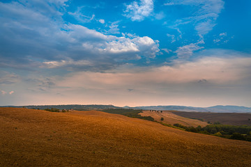 Beautiful warm toned sunset over Val d'Orcia at pink hour. Tuscany, Italy