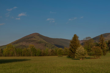 Hills over Trojanovice village in spring sunny color evening