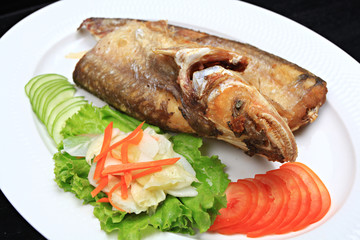 Fried garlic soft fish. Fried river fish with garlic and pepper background