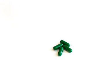 Closed green capsule pills on a white background.Concept of medicine