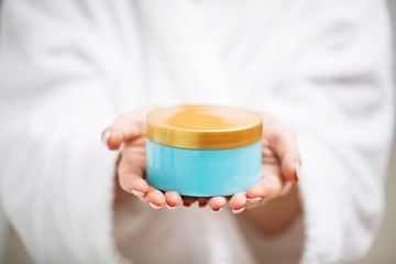 Woman close up holding moisturizer for skin care