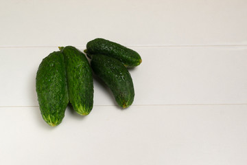 Ugly Siamese-twin cucumbers on a white background. Copy space.