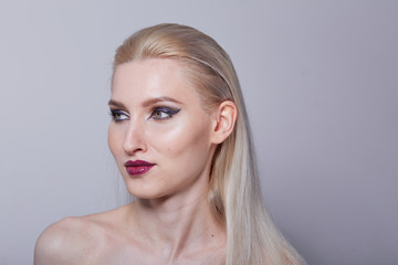 Fashionable, stylish set in the studio with a blonde girl with bright makeup and purple lips.