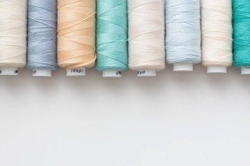 Color sewing threads on white background, top view, flat lay,place for inscription