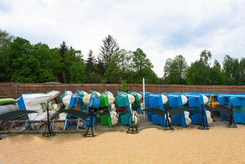 Catamarans on the shore are stacked in a row.