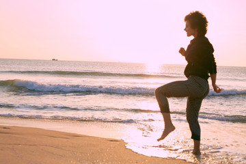 Fototapeta na wymiar Athletic young caucasian girl jogging on the beach one sunny morning. 