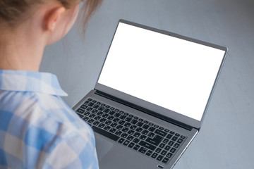 Mock up, copyspace, freelance workspace, template, entertainment and technology concept. Woman looking at grey laptop with white blank screen in home or office - mockup image