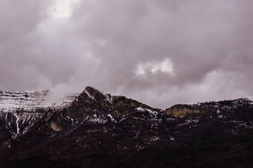 A picturesque landscape view of the high snow capped Alps mountains on a gloomy winter day (Gap, Hautes-Alpes, France)