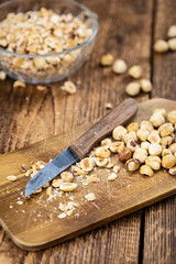 Freshly chopped Hazelnuts on an old wooden table (close up; selective focus)