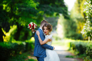 Obraz premium Wedding couple, happy newlyweds and husband hugging in green park.