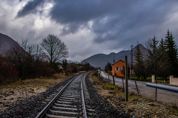 A picturesque view of a railroad track in the French Alps on a cloudy gloomy day in winter (Veynes, Hautes-Alpes, France)