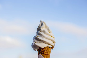 vanilla ice cream cone melting on a sunny say with the sky background  holding it it to the sky summer day stock photo 