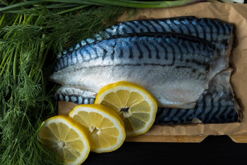 Fish products, commercial fish mackerel. Raw mackerel fillet with skin on a wooden board and on...