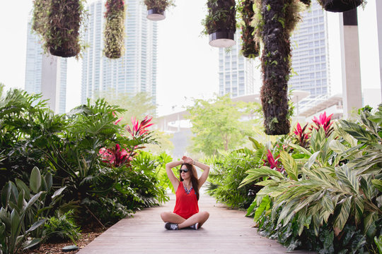 young woman sitting meditating reviving and relaxing in downtown Miami with the view of the city stock photo 