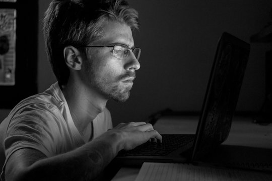 Homem jovem estudando em notebook, home office