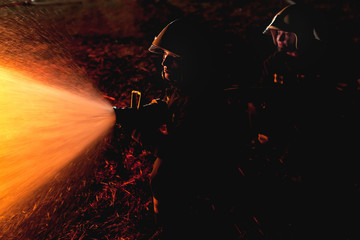 Professional firefighters puttion out a fire with water.