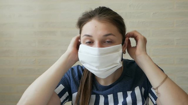 The girl puts on a protective mask and is about to leave the house. Getting ready for the exit. The concept of self-control in viruses and epidemics. Quarantine