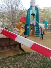 Park, square with playgrounds fenced with ribbons during the coronavirus, quarantine, pandemic. Children on playgrounds, dogs in parks and squares.