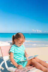 Obraz na płótnie Canvas Little girl with laptop on beach during summer vacation