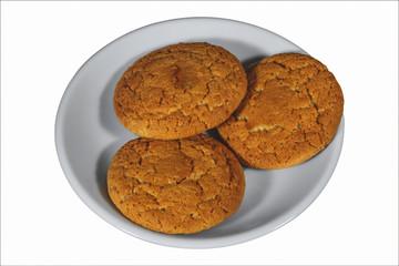 Oatmeal cookies on a white porcelain saucer isolate on a white background.