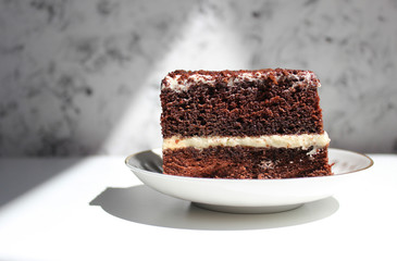 Chocolate brownie cake, dessert with white cream and topping on a light background