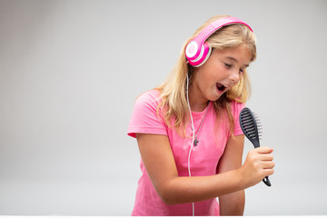 Young girl having fun singing into a hairbrush
