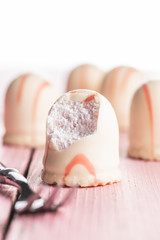 Sweet foam dessert. Marshmallow covered with strawberry icing.