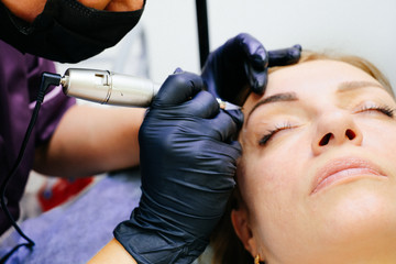 master brow artist makes permanent eyebrow makeup in the technique of powder browsers....