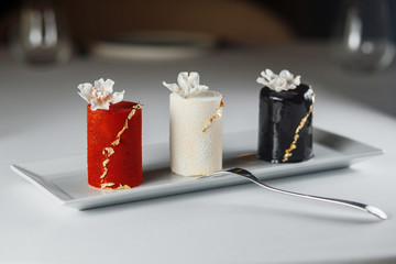 mousse cakes are covered with pastry velour, glaze, and decorated with gold