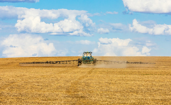 Tractor spraying crops on the prairies
