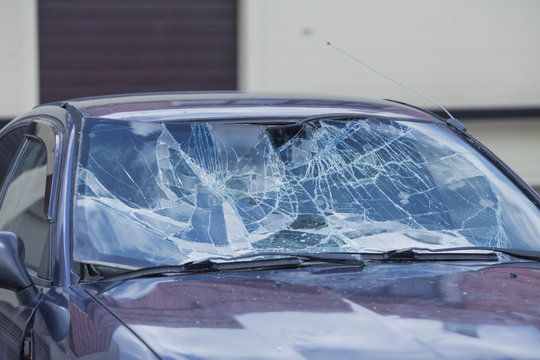 a broken windshield standing on the street of a car