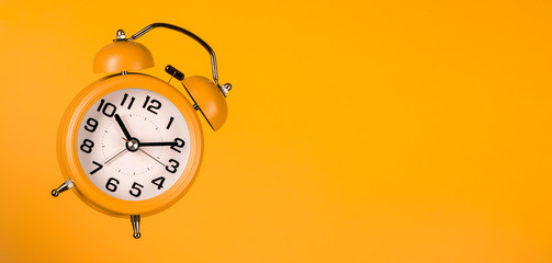 orange alarm clock on orange background