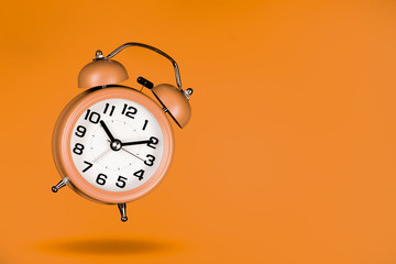 orange alarm clock on orange background