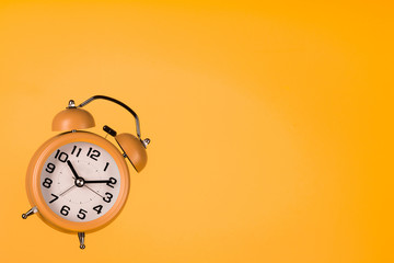 orange alarm clock on orange background