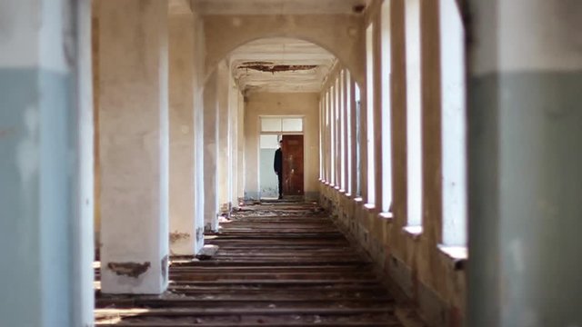 Guy walks through an abandoned building