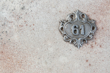 Old aluminum number on concrete background