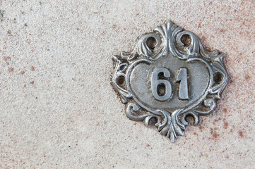 Old aluminum number on concrete background