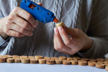 Homemade cork panel, woman makes wine cork note board, selective focus