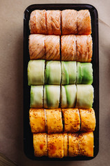 Freshly cooked sushi chef, delicious big rolls with avocado, cheese, salmon, sesame seeds 