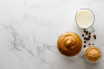 Korean coffee drink. Iced Dalgona coffee on light marble table. Trendy refreshment creamy whipped coffee. Top view, copy space.