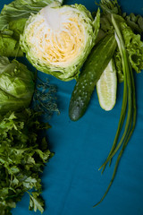 Obraz premium Close-up of fresh green vegetables on green tablecloth, selective focus