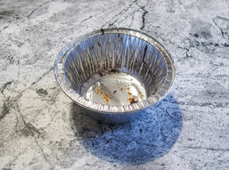Dirty used foil tray for dessert. Aluminum. Granite background