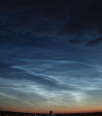 Fototapeta na wymiar Noctilucent clouds over Poland. Evening sky covered by NLC.