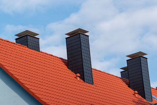 chimney on blue house with red roof  in Europe 